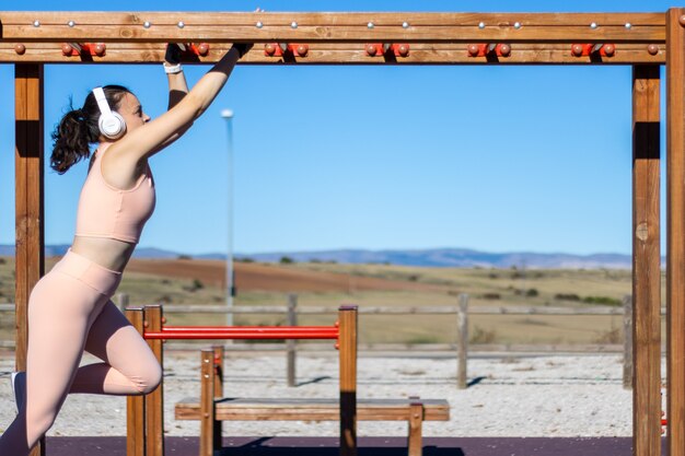 Ćwiczenia fitness kobieta lekkoatletka ćwiczenia na barach. Crossfit człowiek ćwiczący ramiona kołysanie na drabinie brachiation jako rutyna treningu siłowego crossfit.