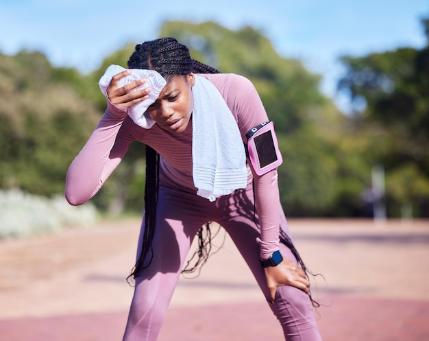 Ćwiczenia potu i czarna kobieta na świeżym powietrzu zmęczona i biegająca dla równowagi odnowy biologicznej lub cardio Afroamerykanka lekkoatletka biegaczka i dama z ręcznikiem odpoczywa lub odpoczywa po treningu lub relaksie
