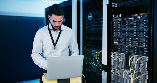 Cybersecurity upgrade and man with laptop coding or check server performance and network engineer Data center IT specialist and person with tech for software update power cables and electricity