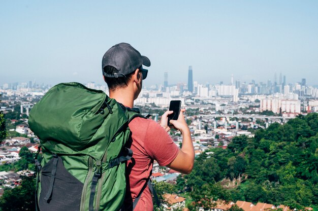 Cyfrowego koczownika mężczyzna podróżuje świat pracuje z smartphone