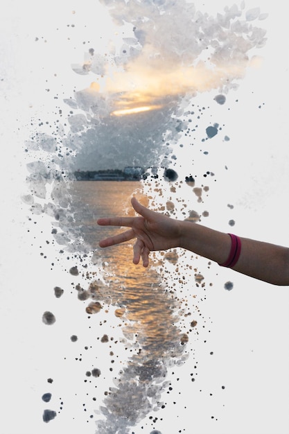 Zdjęcie cyfrowy kompozytowy obraz ręki i jeziora podczas zachodu słońca