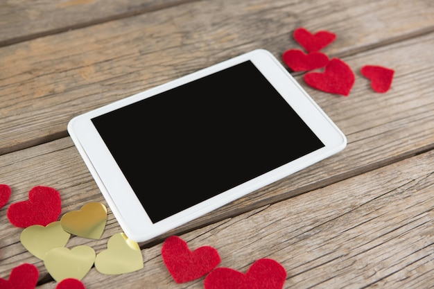 Cyfrowy tablet otoczony dekoracją w kształcie serca