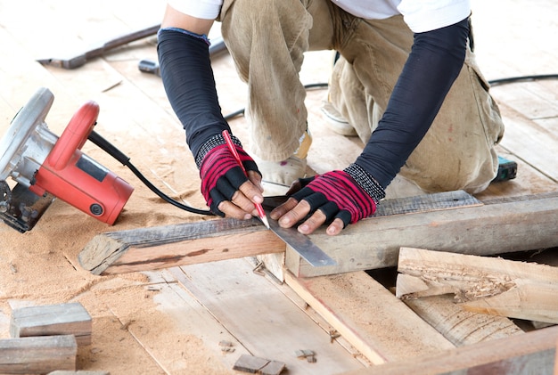 Cz? Owiek Carpenter pomiaru deski z drewna do domu budynku