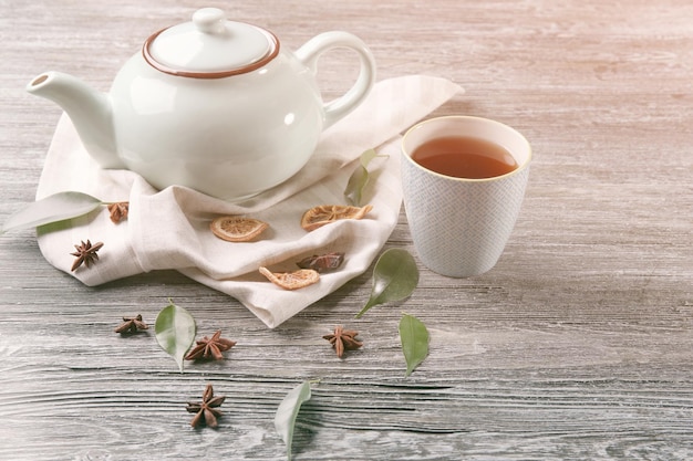 Zdjęcie czajnik i filiżanka z herbatą na drewnianym tle