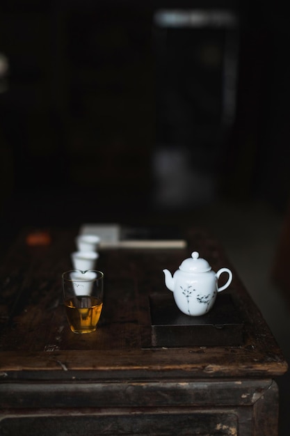 Czajnik i szklanka płynu leżą na stole Zaparz herbatę i delektuj się nią w domu, relaksując się