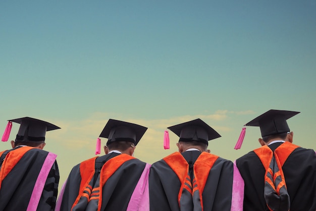 czapka absolwentów za jasne błękitne niebo, absolwenci stoją w kolejce na kampusie