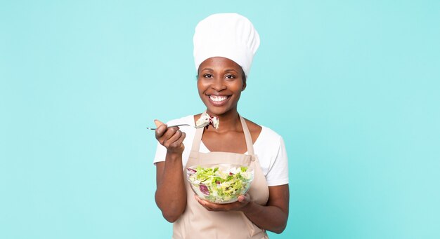 Czarna afroamerykańska dorosła kobieta kucharz trzyma sałatkę