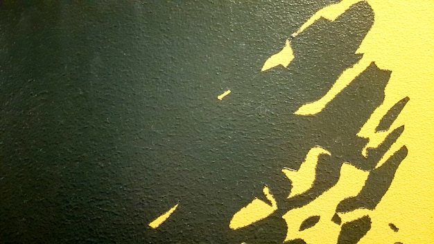 Zdjęcie czarna farba abstrakcyjna plamy kapie na jasnożółtym tle. czarna farba plamy na żółtym tle. koncepcja pomysłów artystycznych. pędzel tekstura żółty i czarny na tle.