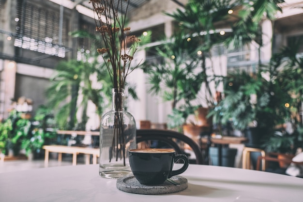 Czarna filiżanka gorącej kawy na stole w kawiarni
