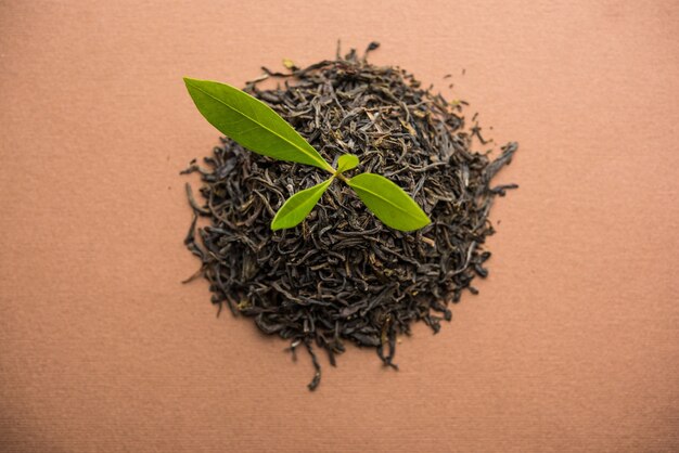 Czarna herbata w proszku lub suchy pył z zielonym liściem lub bez i podawana gorąca herbata w filiżance