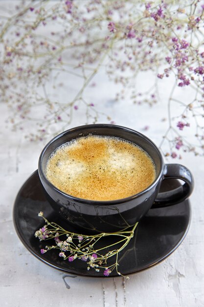 Czarna kawa ozdobiona kwiatami