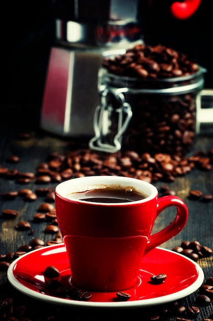 Czarna kawa w czerwonej filiżance czarne tło selektywne focus
