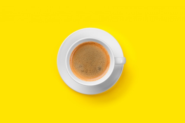 Czarna kawa w filiżance na żółtym tle