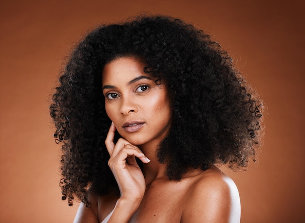 Czarna kobieta afro uroda i myślenie w makijażu do pielęgnacji skóry lub kosmetykach na tle studia Portret ciekawej afroamerykańskiej modelki pozuje z ręką w myśli na zabieg na twarz