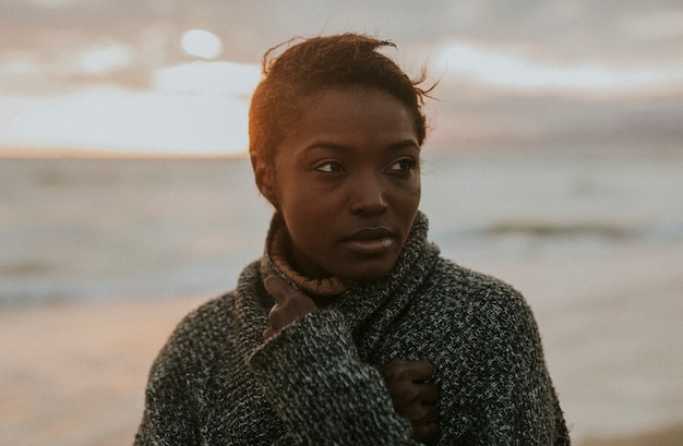Czarna kobieta na plaży o zachodzie słońca