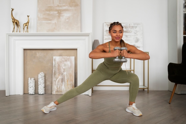 Zdjęcie czarna kobieta robi fitness w domu