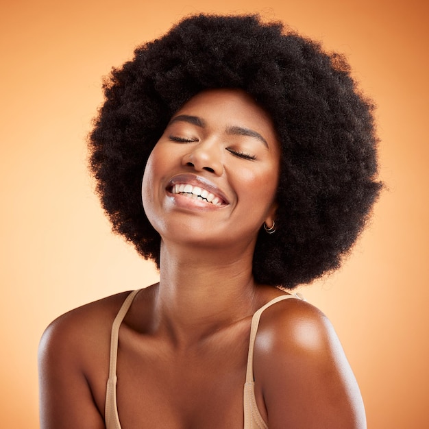 Czarna kobieta twarz naturalne piękno i pielęgnacja skóry zdrowie wellness na pomarańczowym tle ściany studia Szczęśliwy afrykański model uśmiecha się czarna kobieca inicjacja i zdrowy kosmetyk luksusowa moda afro pielęgnacja włosów