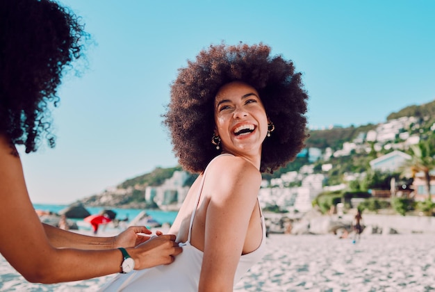 Czarna kobieta z filtrem przeciwsłonecznym i przyjaciele na plaży na szczęśliwe wakacje lub wakacje, aby zrelaksować się ze swobodą w podróży Miami Smile i kobiety pomagające młodej dziewczynie z pokolenia z kremem do pielęgnacji skóry na plecach na morzu