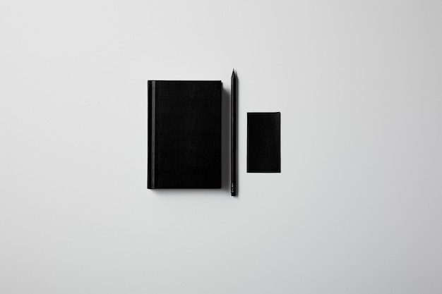 Czarna księga, notatnik i czarne pióro na białym tle.