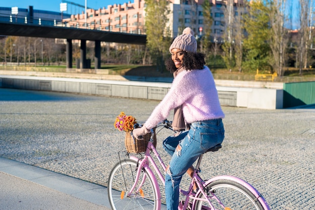 Czarna młoda kobieta jedzie rocznika bicykl