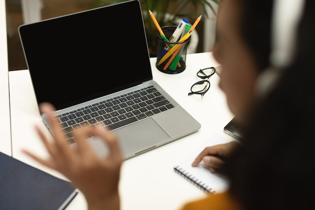 Czarna nauczycielka wideorozmowa przez laptopa i gestykuluje w porządku znak na pusty ekran komputera po lekcji online