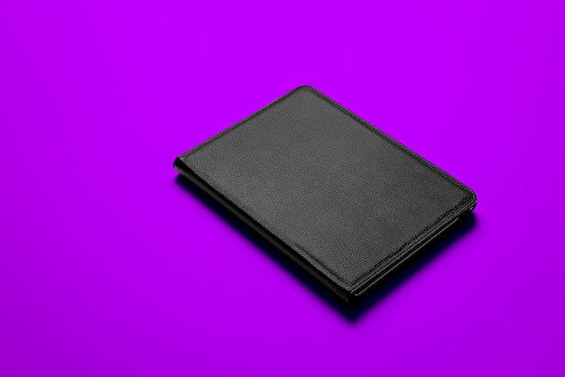 Zdjęcie czarna obudowa smart pad makieta czarny skórzany materiał z płaskim kolorowym tłem