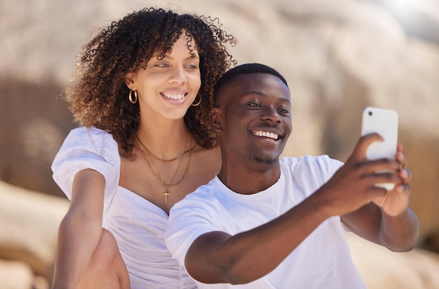 Czarna para uśmiecha się do selfie i plaży z kobietą i mężczyzną razem do zdjęcia profilowego w mediach społecznościowych Zdjęcie miłosne i letnia podróż młodych ludzi na świeżym powietrzu z swobodą na wakacjach ze szczęściem