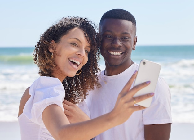 Czarna para uśmiecha się selfie i wody morskiej z kobietą i mężczyzną razem do zdjęcia profilowego w mediach społecznościowych Opieka miłosna i letnie podróże młodych ludzi na świeżym powietrzu z swobodą na wakacjach ze szczęściem