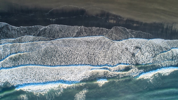 Zdjęcie czarna piasek plaża w iceland. widok na morze i widok z góry.