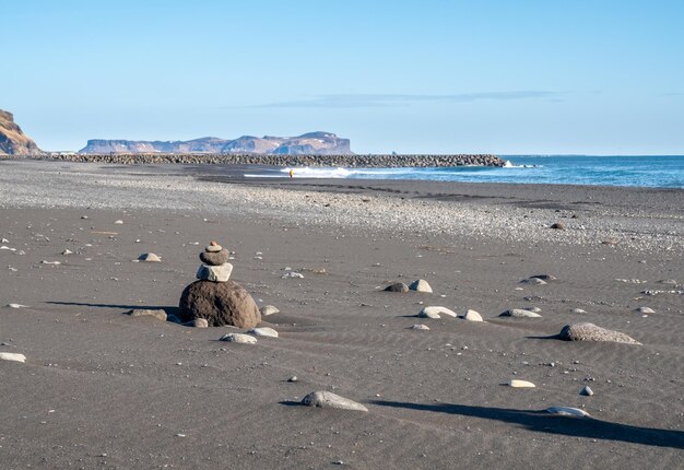 Czarna plaża Reynisfjara jest symbolem miasta Vik na Islandii, otoczonego bazaltowymi górami