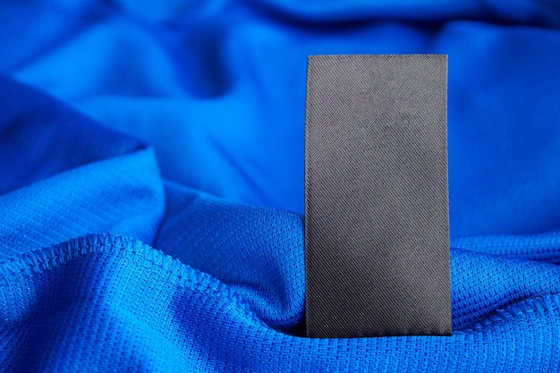 Czarna pusta etykieta odzieży do prania na niebieskim tle koszuli sportowej z poliestru jersey