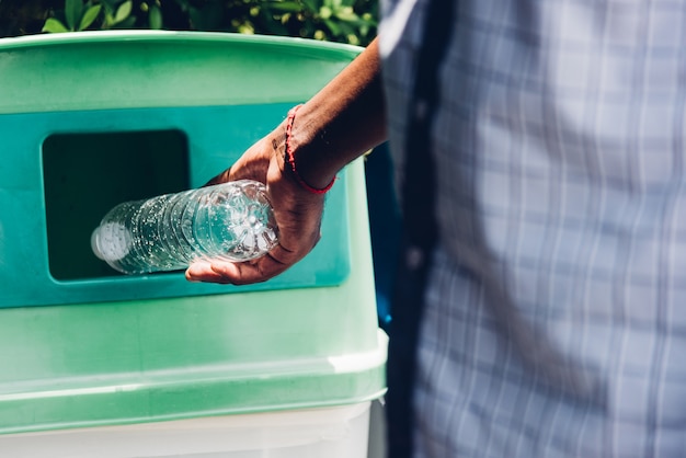 Czarna Ręka Mężczyzny Rzucająca Pustą Plastikową Butelkę Po Wodzie Do Recyklingu śmieci