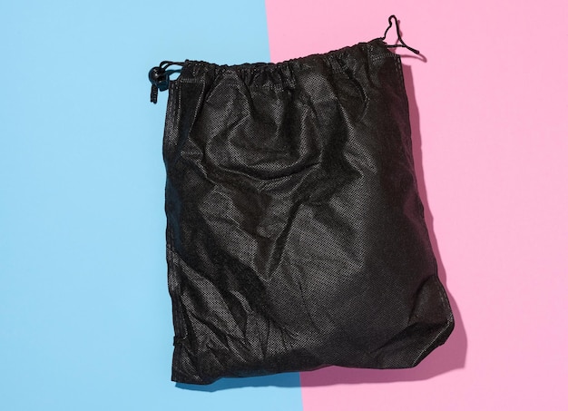 Czarna tekstylna torba z liną na niebiesko-różowym, izolowanym tle