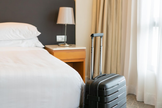 Czarna walizka podróżna w sypialni lub pokoju hotelowym i tle zasłony okiennej Relaksujący czas w weekend świąteczny i podróżująca koncepcja podróży służbowej