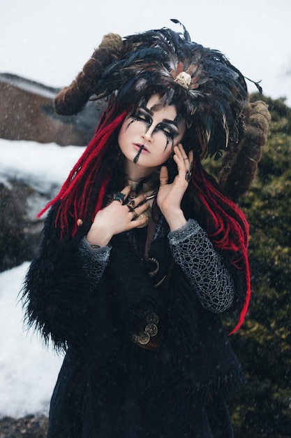 czarna wiedźma w koronie z rogami i piórami w czarnej futrzanej pelerynie podczas burzy śnieżnej