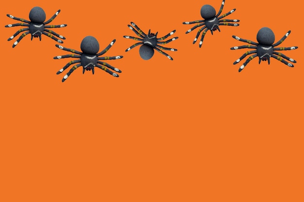 Czarne pająki na pomarańczowym tle z miejscem na tekst Motyw Halloween Plakat banner