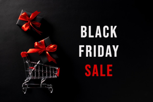 Zdjęcie czarne prezenty i koszyk z tekstem black friday sale.