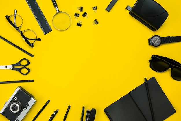 Czarne przedmioty z biura na żółtym tle praca i kreatywność widok z góry