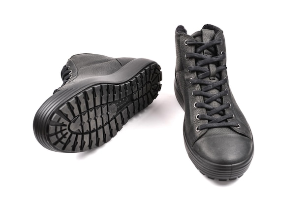 Czarne skórzane buty męskie i czarny aparat na czarnym tle
