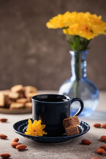 Czarne świeżo parzone espresso w niebieskiej filiżance ze spodkiem i goframi