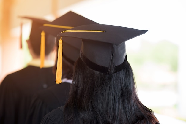 Czarni absolwenci noszą czarne kostiumy w dniu ukończenia studiów na uniwersytecie.