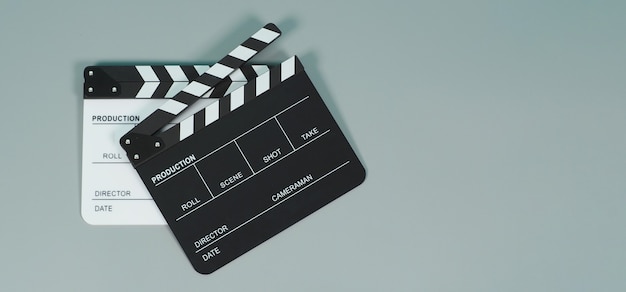 Czarno-białe clapperboard lub clapper board lub klapki filmowe do wykorzystania w produkcji wideo, filmie, przemyśle kinowym na szarym tle.