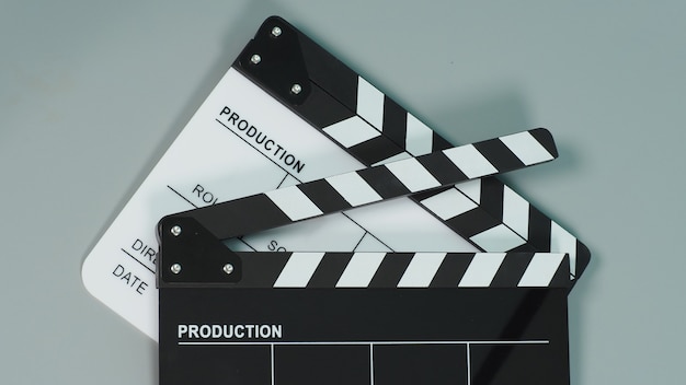 Zdjęcie czarno-białe clapperboard lub clapper board lub klapki filmowe do wykorzystania w produkcji wideo, filmie, przemyśle kinowym na szarym tle.