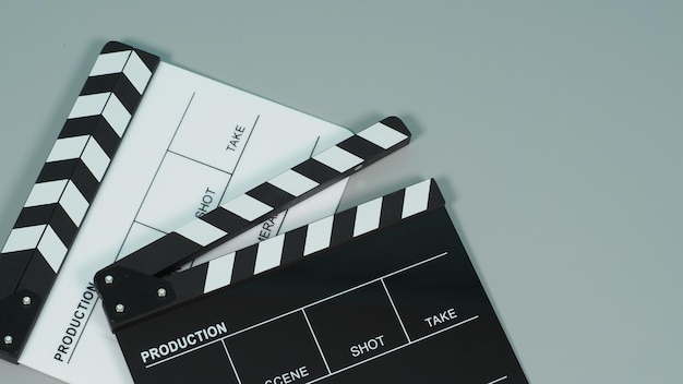 Czarno-białe clapperboard lub clapper board lub tabliczka filmowa do wykorzystania w produkcji wideo, filmie, przemyśle kinowym na szarym tle.