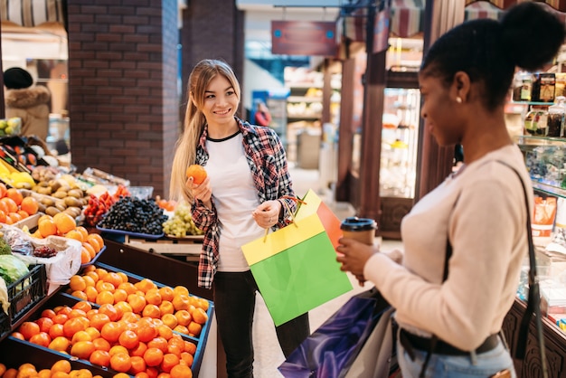 Czarno-białe kobiety kupują owoce po zakupach.