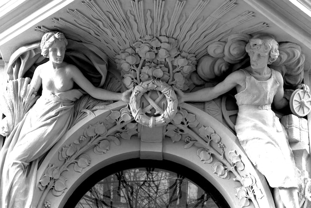 Czarno-białe zdjęcie dwóch posągów z toporem pośrodku.