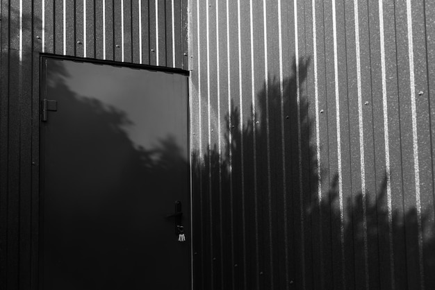 Czarno-białe zdjęcie metalowych drzwi metalowej stodoły
