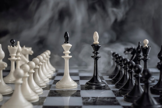 Czarno-biały królowie szachowej konfiguracji na ciemnym tle.