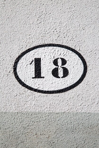 Czarno-biały numer osiemnaście na kamiennej ścianie