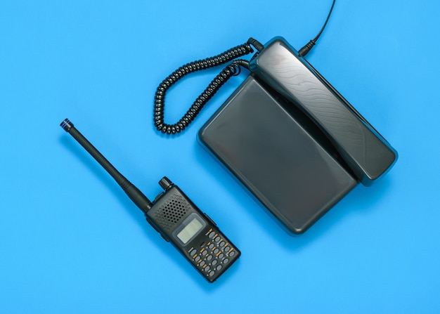 Czarno-biały obraz krótkofalówki i telefonu na niebieskim tle.